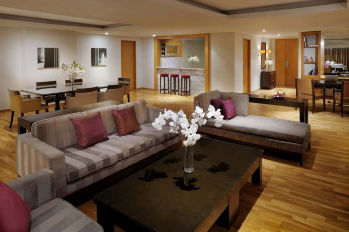 living room with grey couches brown coffee table and stools in the background
